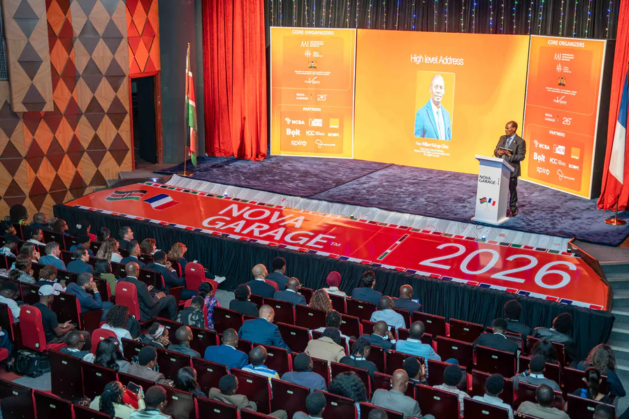 A full auditorium at the Nova Garage Summit 2026, with Kenyan and French flags flanking the stage during the high-level address.